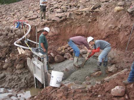 10-East Timothy Stabilization, crew batch and pour cement on new head structure on existing outlet pipe