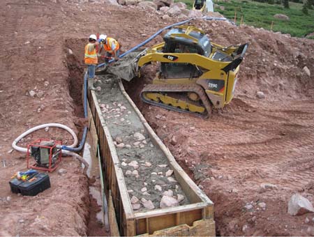 15-East Timothy Stabilization, pouring 3rd gabion basket using skidsteer for transporting cement